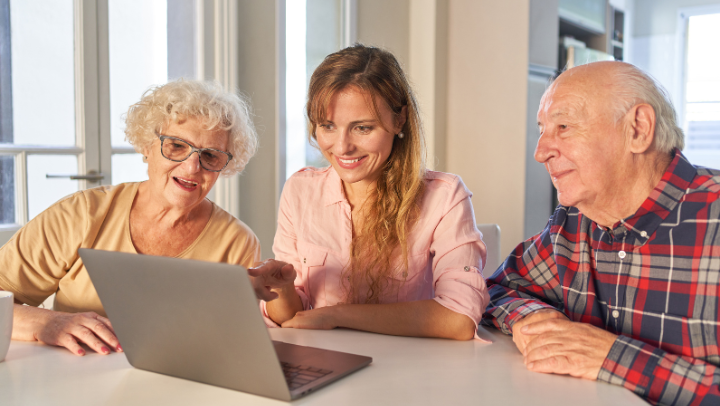a girl looking at a computer with her parents